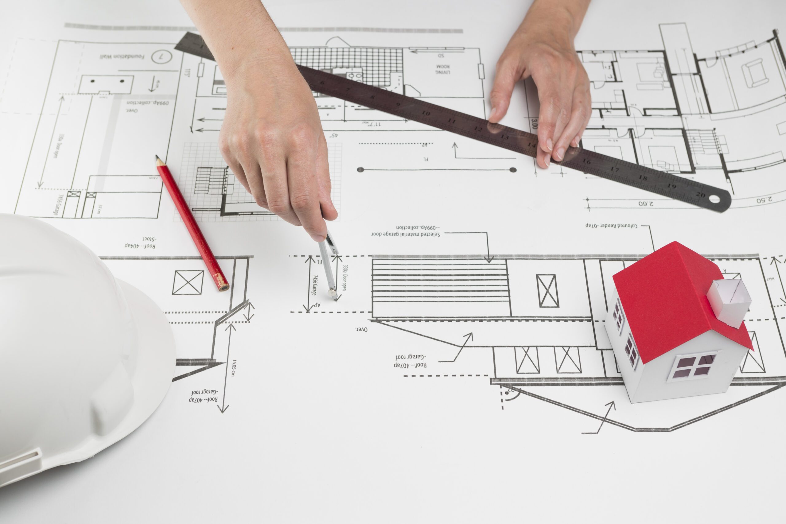 close-up-de-mao-desenho-ligado-blueprint-em-escritorio-scaled.jpg